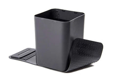 A medium-sized black car trash can with no lid and a pair of dark colored grip strips attached to its base.