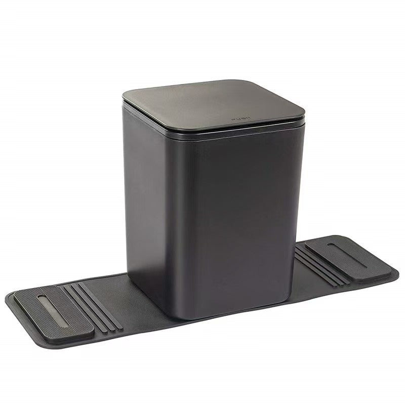 A medium-sized black car trash can with lid and a pair of dark colored grip strips attached to its base.
